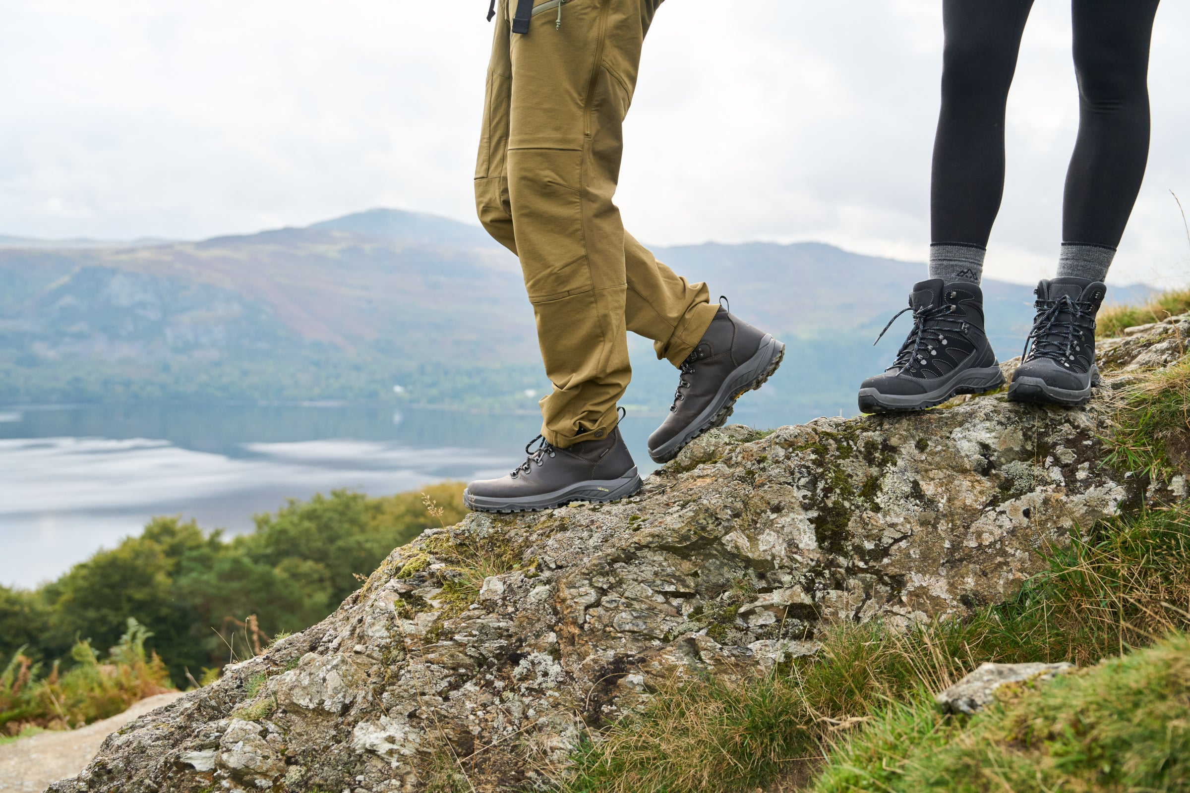 Two people wearing rugged hiking boots standing on a rocky outcrop