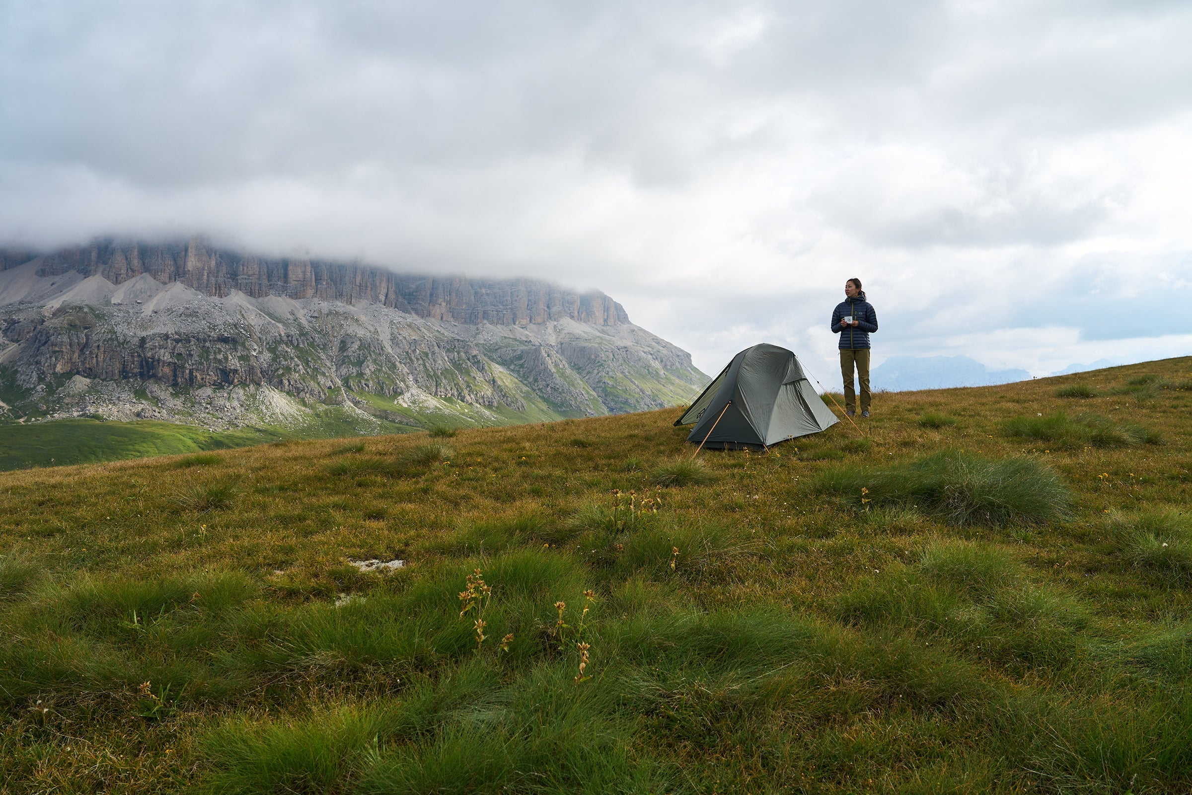 Woman camping in the mountains with a tent