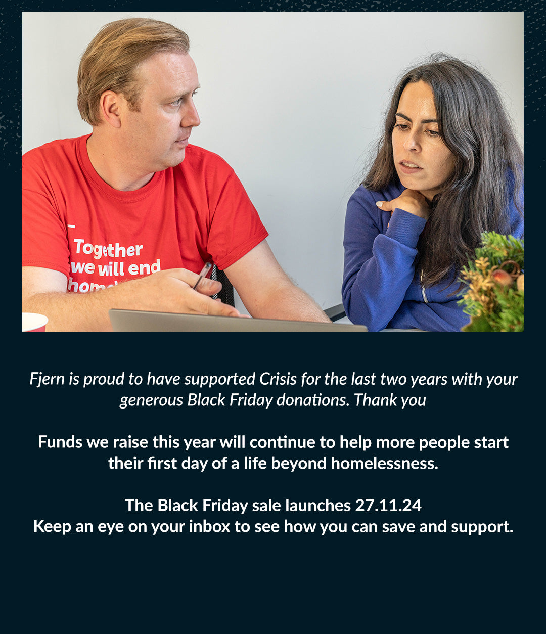 Two people in a meeting, one wearing a red Crisis T-shirt, discussing homelessness support