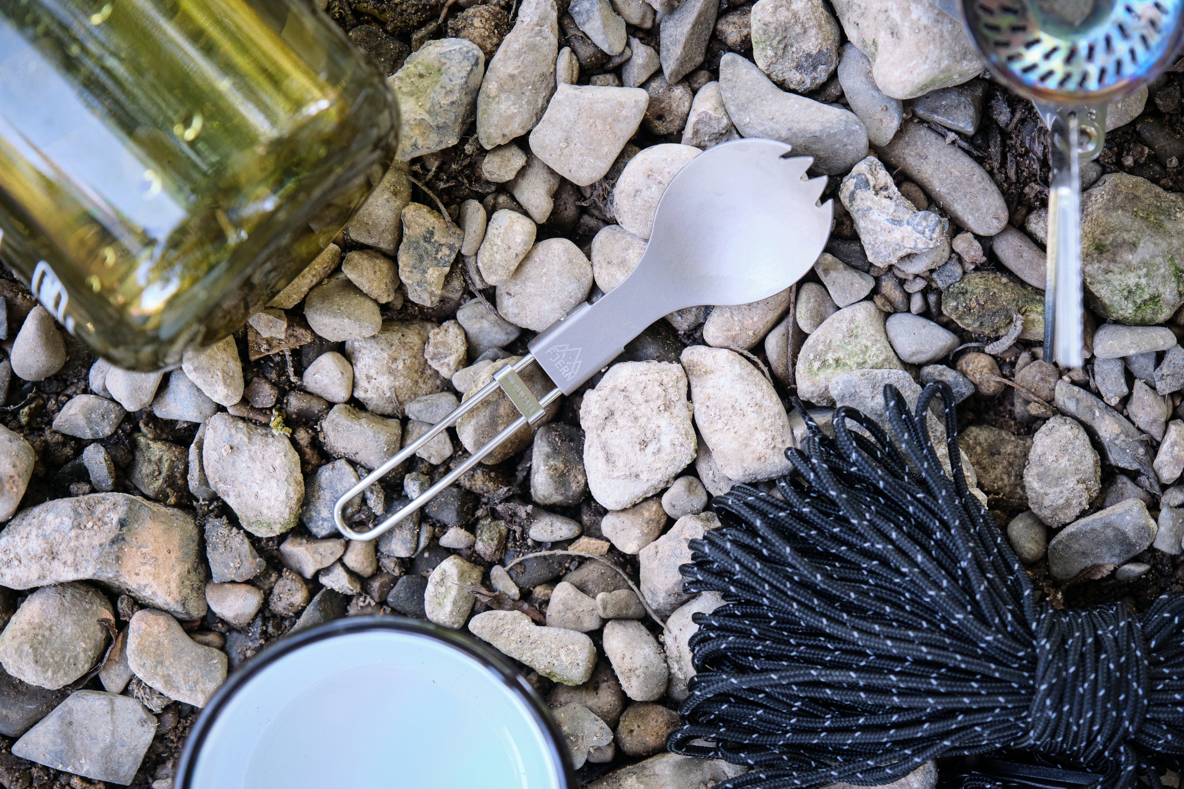 A Fjern spork and other camping gear on rocky ground