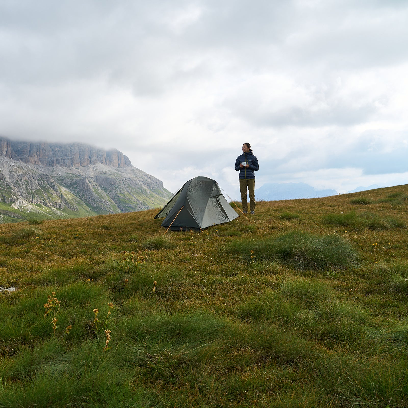 Woman camping in the mountains with a tent