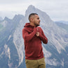 Fjern - Mens Första Merino Blend Long Sleeve Hoodie Baselayer (Rust) | Embark on your next adventure with the Första Hoodie, a lightweight and high-performance technical hoodie